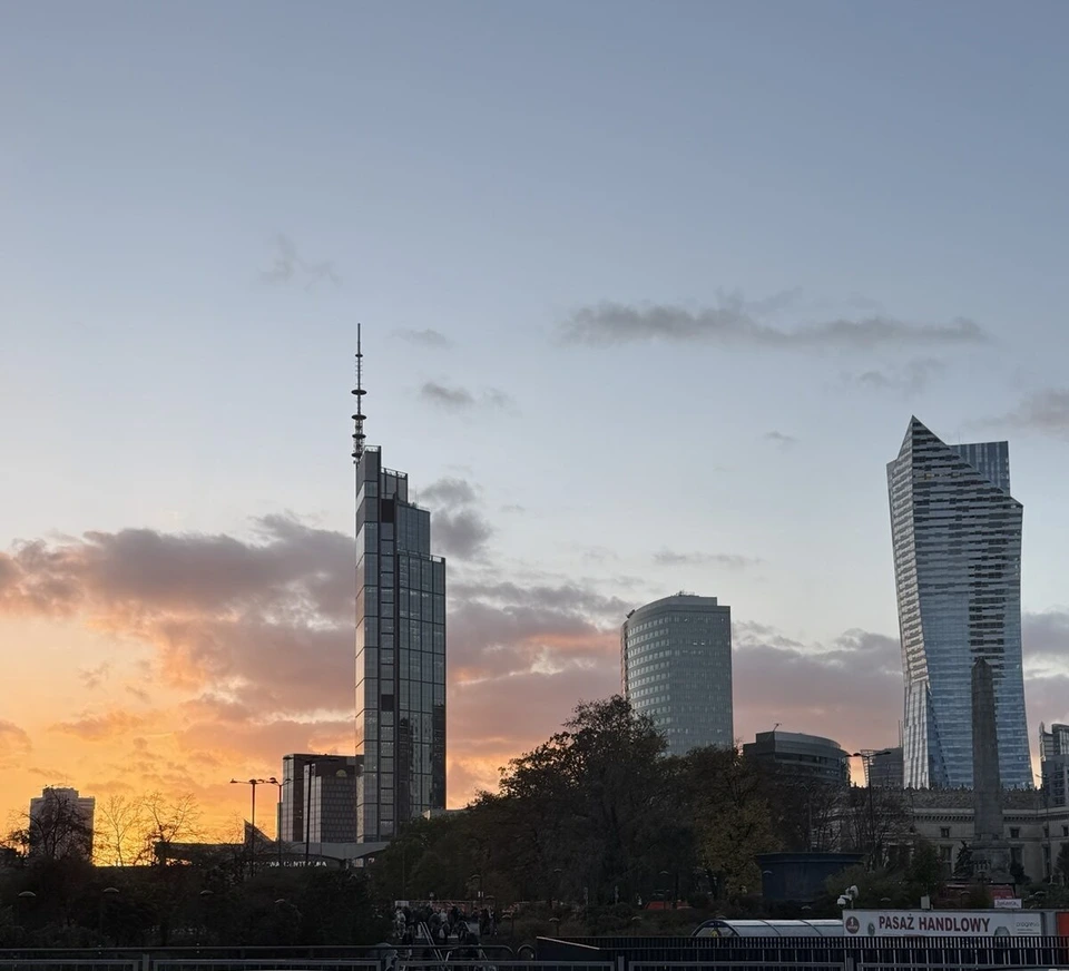 夕焼けの空に立つ、先に細い尖塔のついたヴァルソ・タワーと高層ビル群