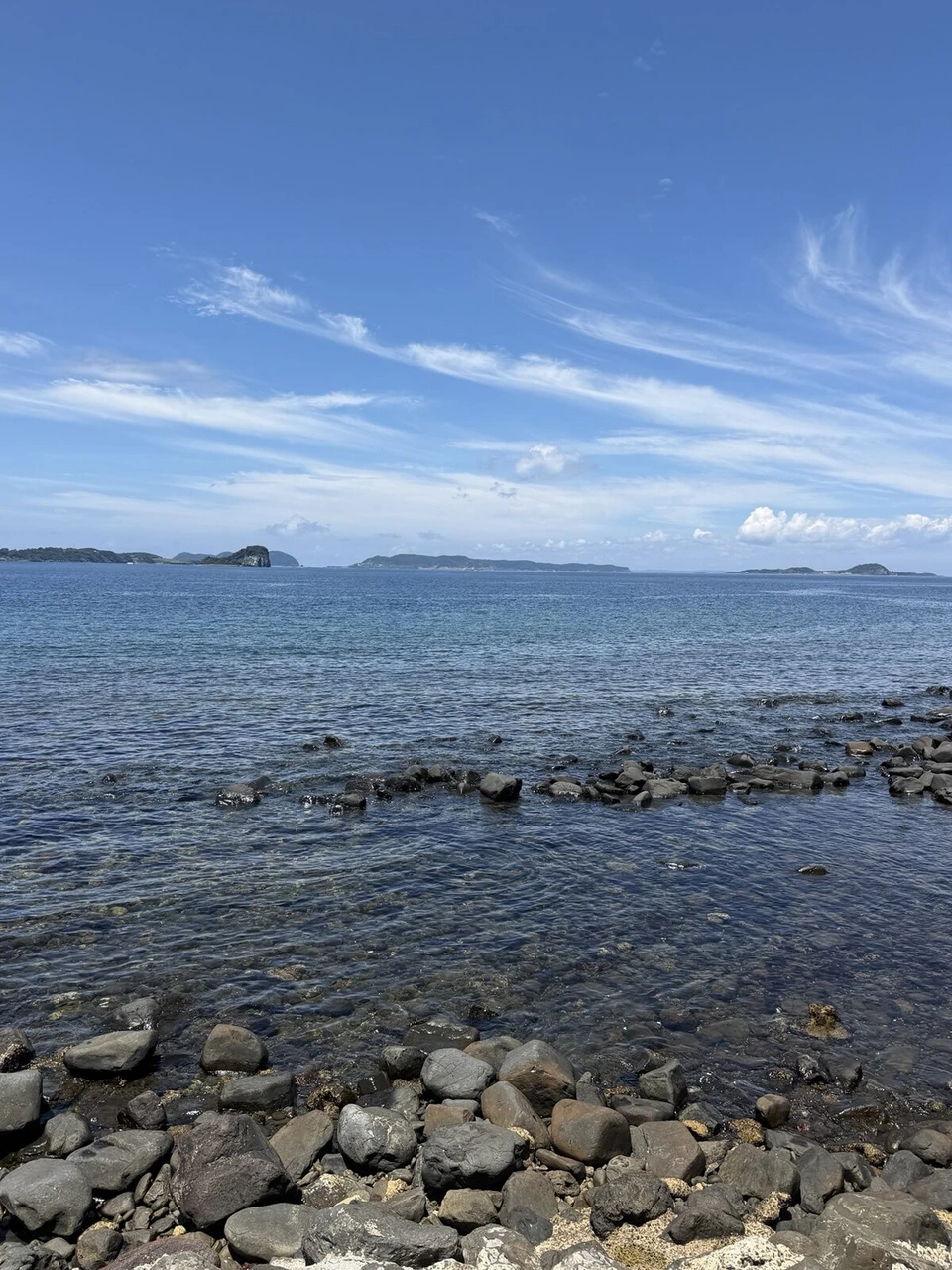 丸い石が転がる七ツ釜近くの浜と、穏やかな玄界灘