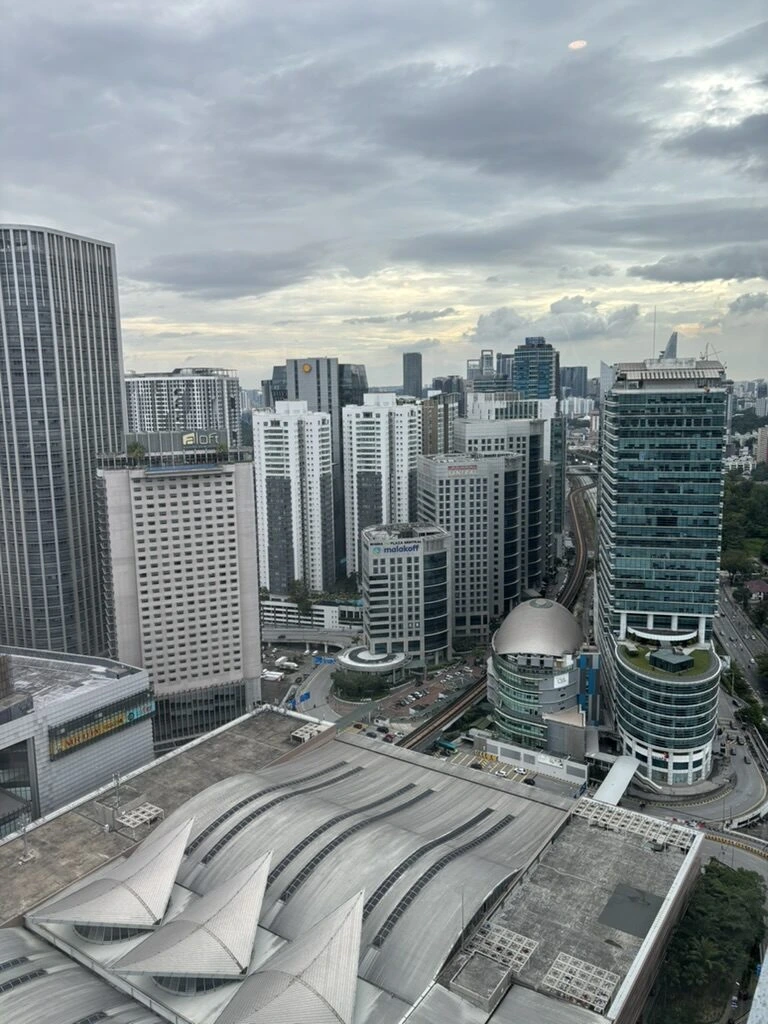 AC Hotel Kuala Lumpurの14階の窓から見たビル群と、銀色のドームのある建物