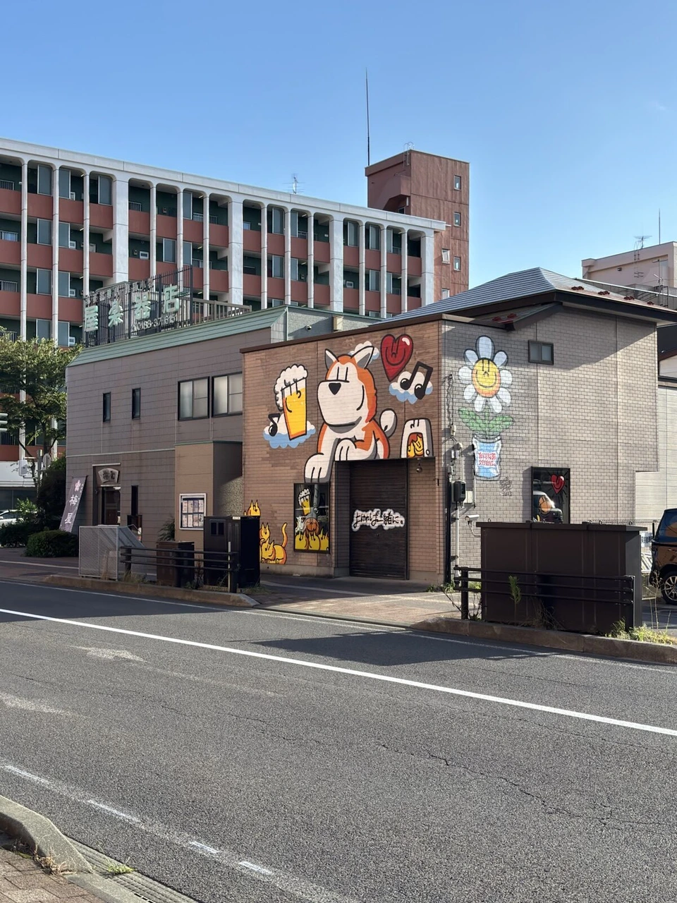 秋田市内の通り沿いの建物。秋田犬のような犬がジョッキを持つ大きな壁画