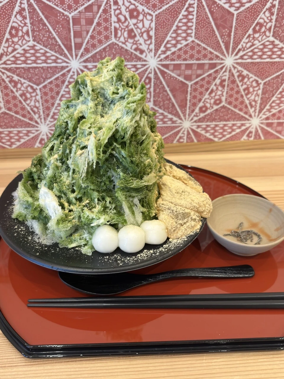 抹茶シロップのかき氷に白玉ときな粉もちが添えられている
