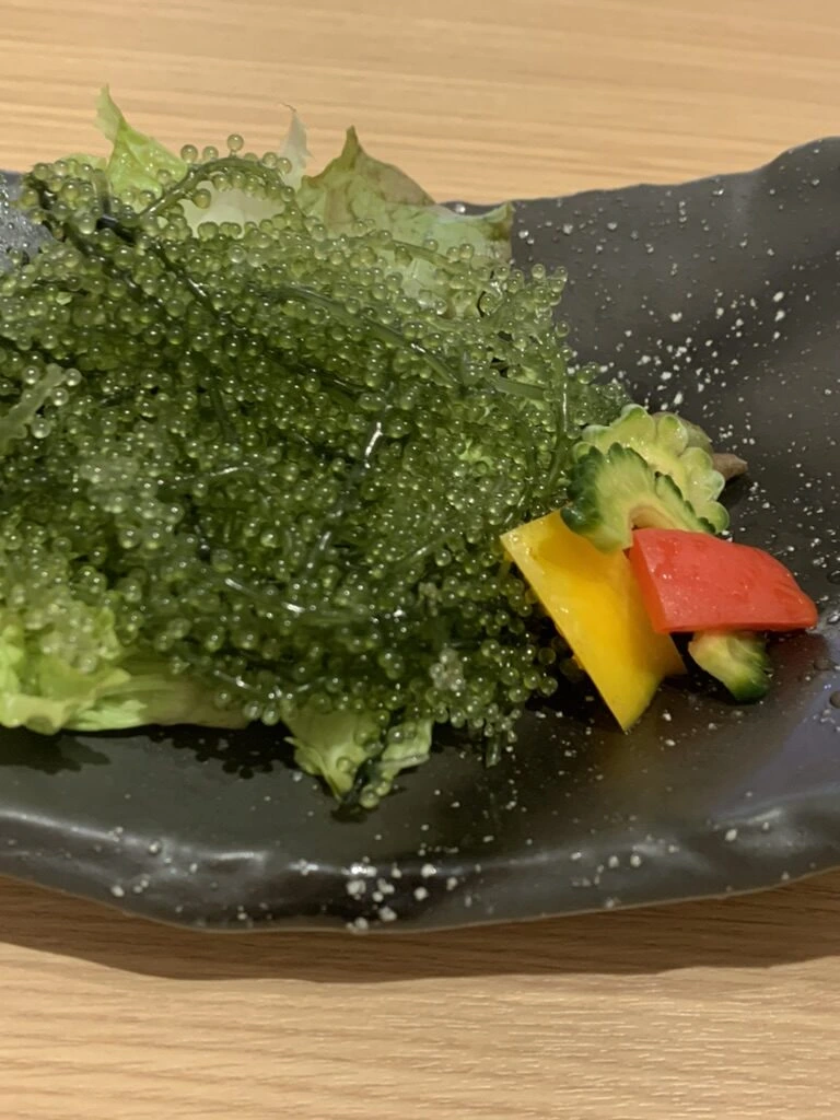 海ぶどうのアップ。ゴーヤーやパプリカが添えてある