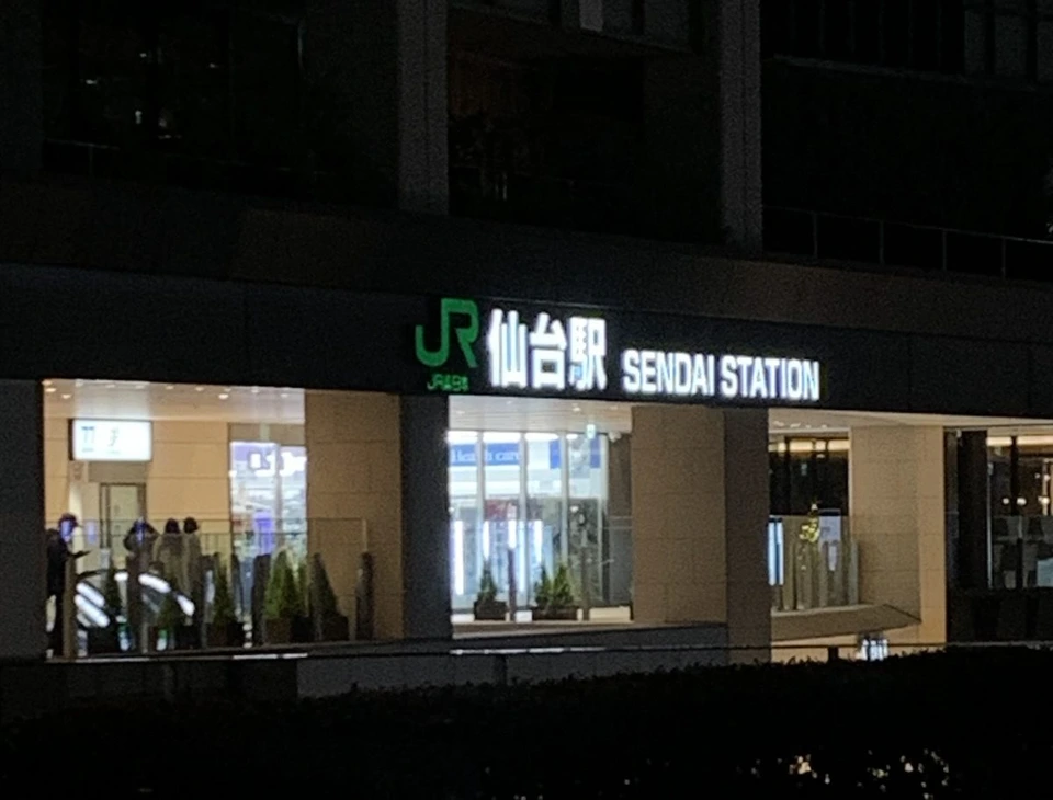 夜のJR仙台駅。駅ビルに光る「JR 仙台駅 SENDAI STATION」の文字