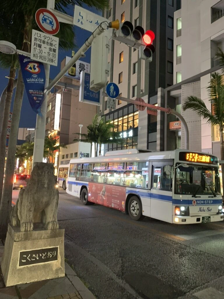 夜の国際通り。コンフォートホテル那覇県庁前から歩いてすぐの「こくさいどおり」の台座のシーサー像と路線バス