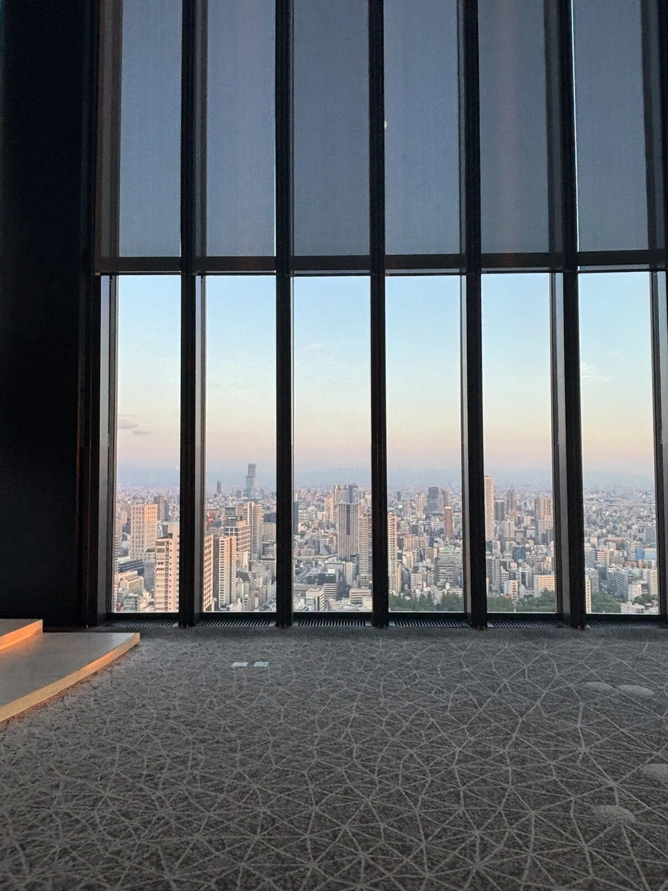 コンラッド大阪40階ロビーの縦長の窓から見た夕方の大阪の街並み