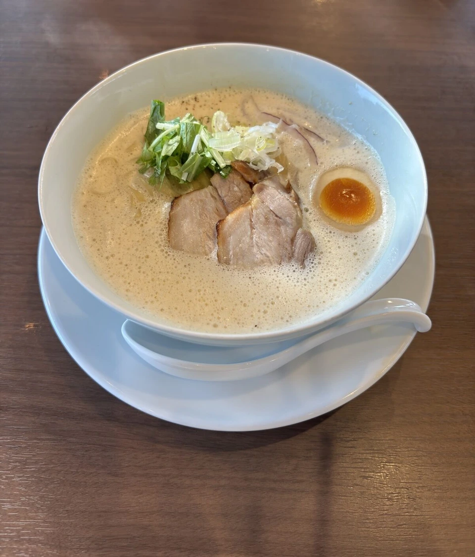 鳴門のラーメン店の白湯ラーメン。チャーシュー2枚、半熟の味玉、ねぎと水菜がのっている