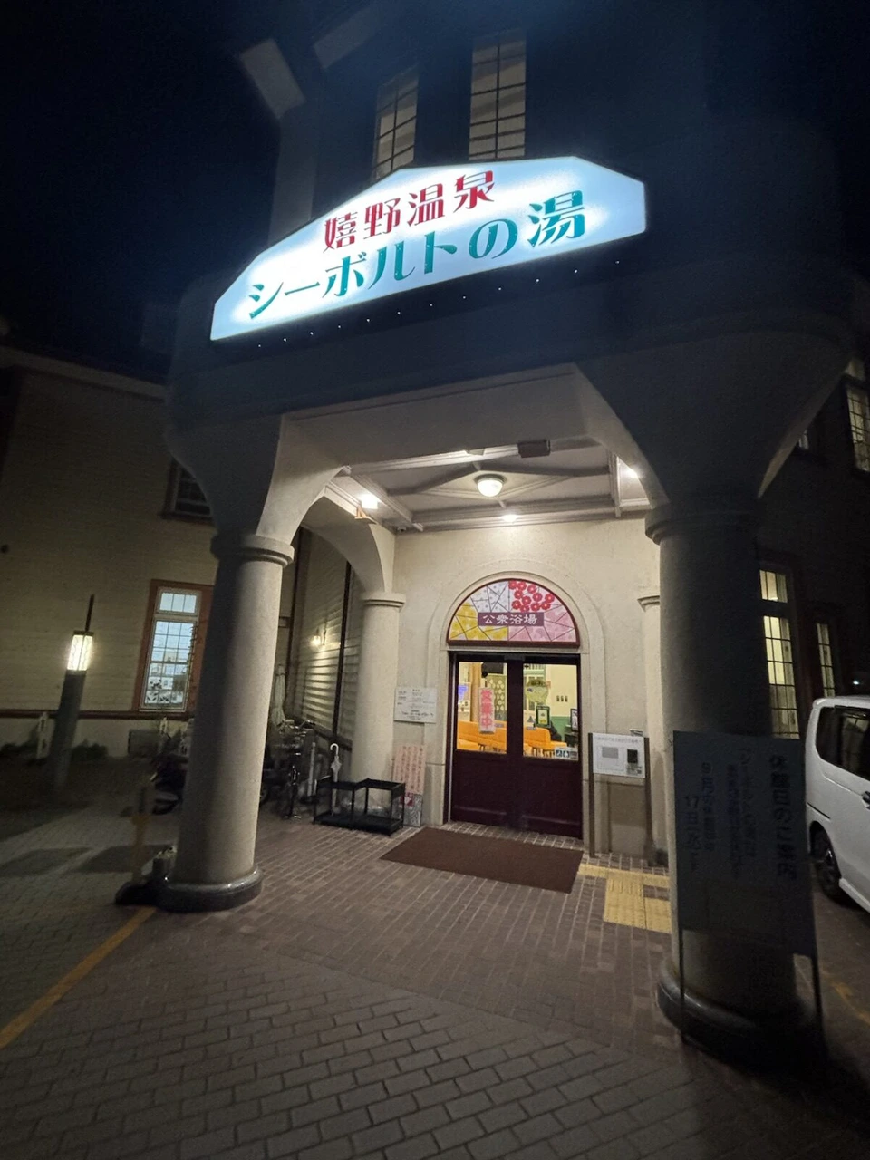 夜の嬉野温泉シーボルトの湯の入口。光る看板とステンドグラス