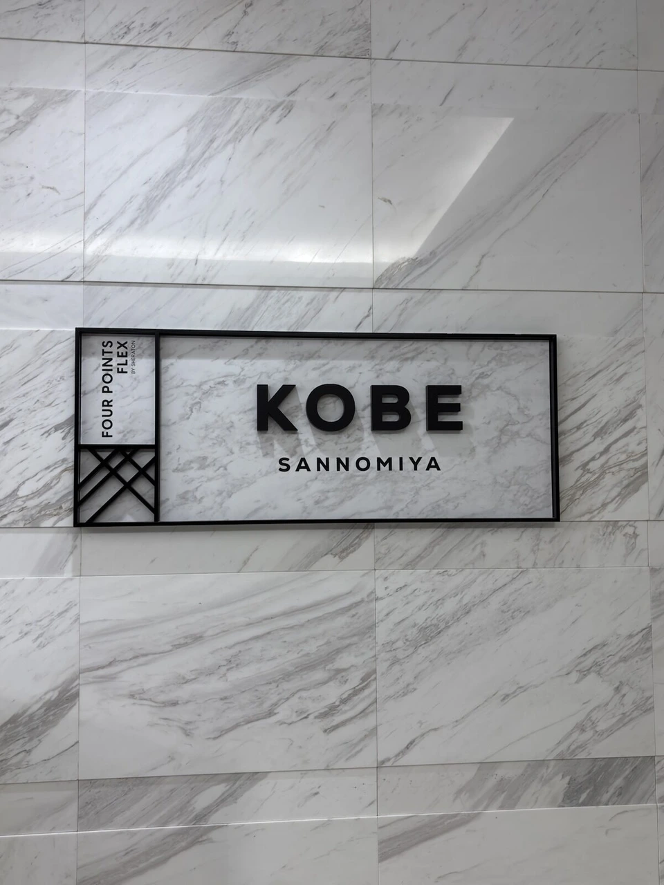 大理石調の壁に掲げられたFOUR POINTS FLEX KOBE SANNOMIYAのサイン