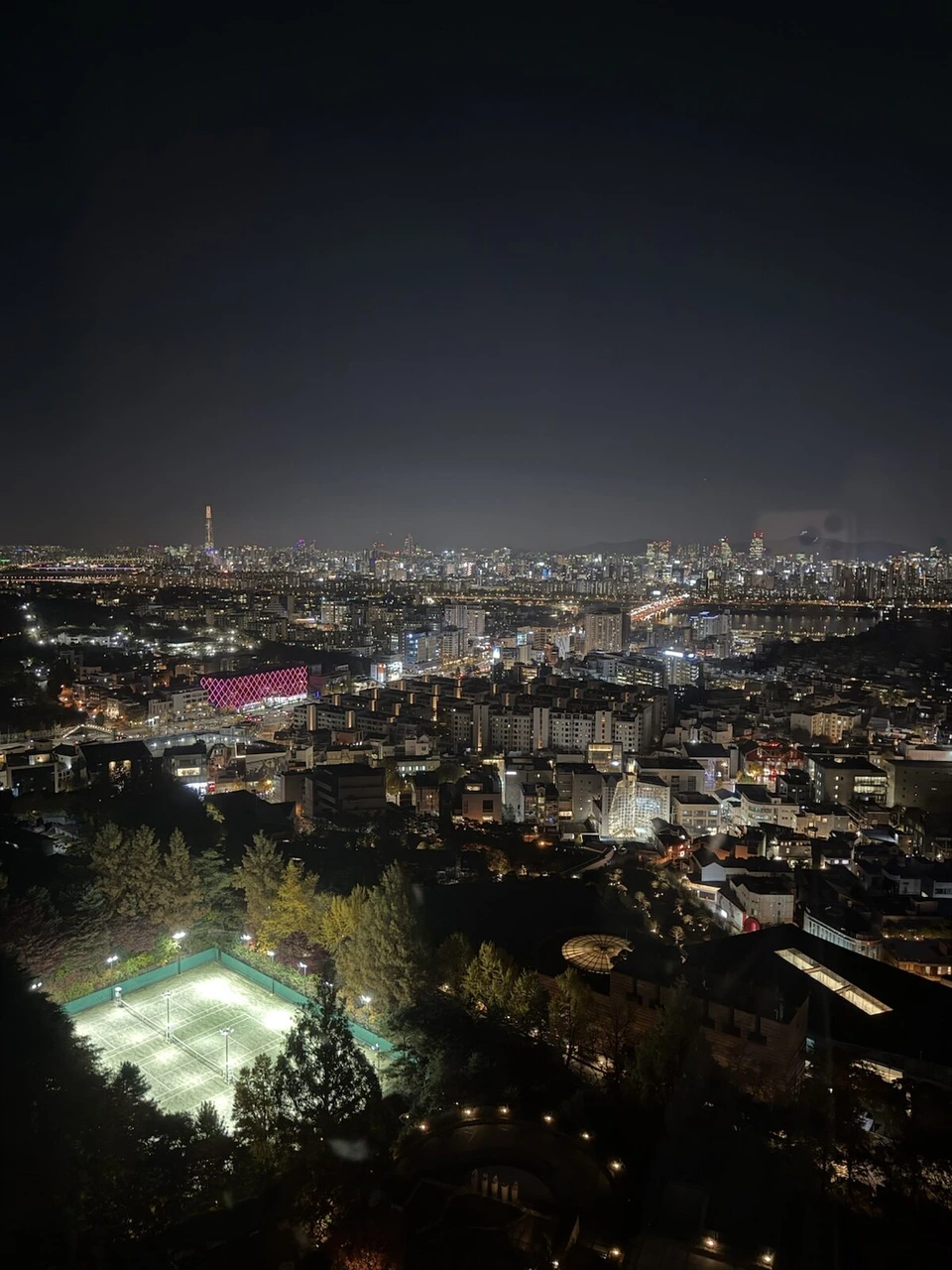 グランド ハイアット ソウルの部屋の窓から見た夜景。手前にライトアップされたテニスコート、奥に漢江とロッテワールドタワー