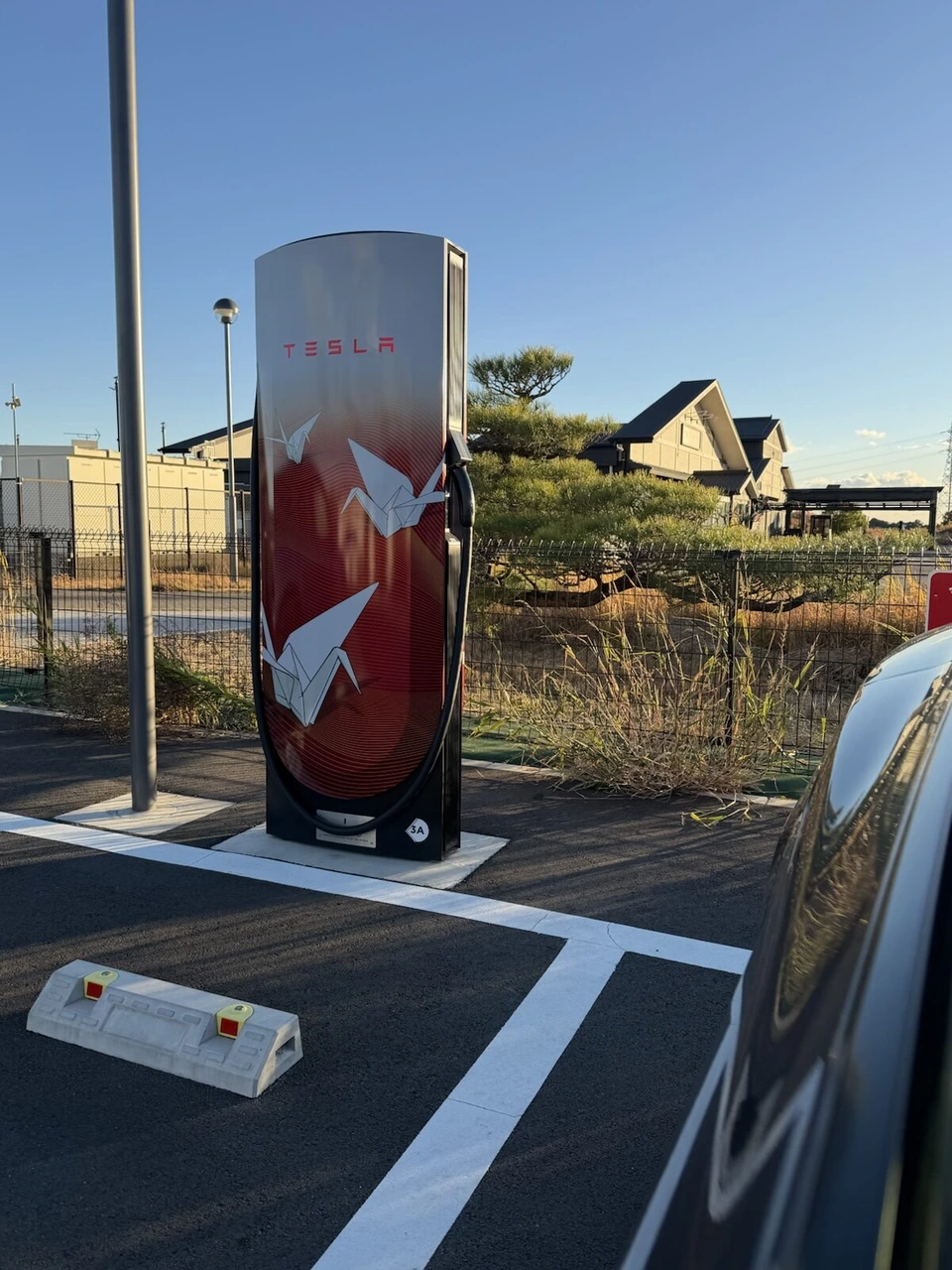 静岡県内のテスラ・スーパーチャージャー。折り鶴の絵が描かれた赤い充電器