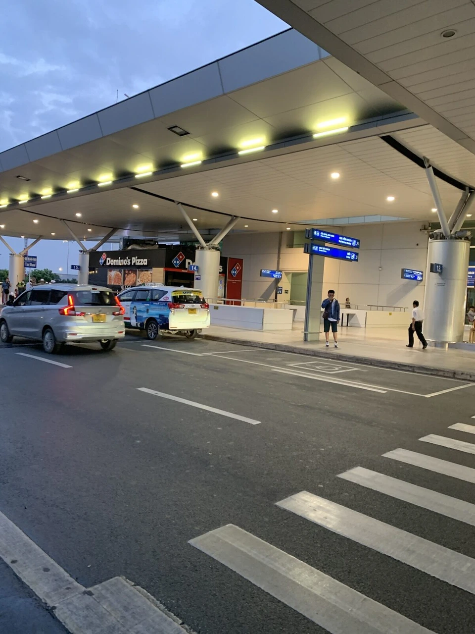 明け方のタンソンニャット空港の出発階の車寄せ。屋根の下にタクシーと横断歩道