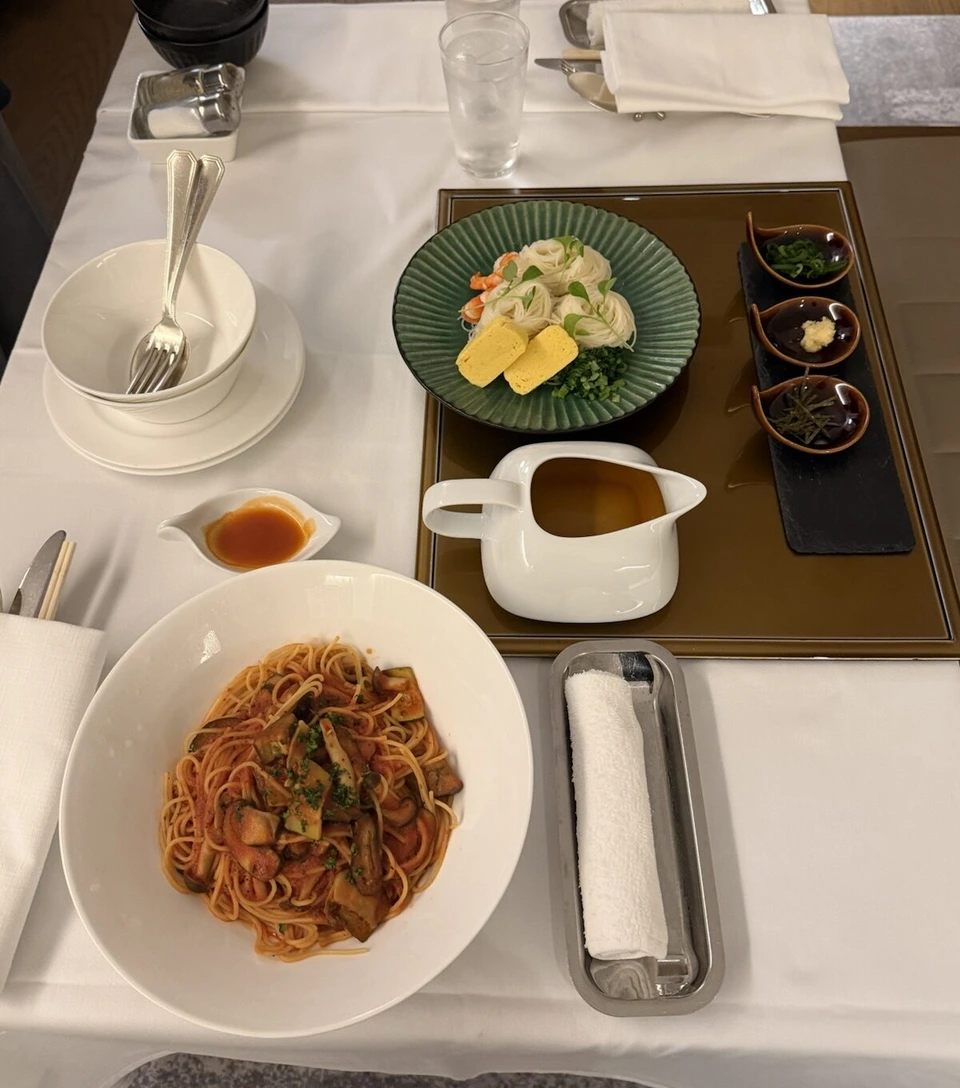 JWマリオット・ホテル奈良のルームサービス。白いクロスの上にトマトソースのパスタ、そうめんと出汁、薬味の小皿が並んだルームサービス
