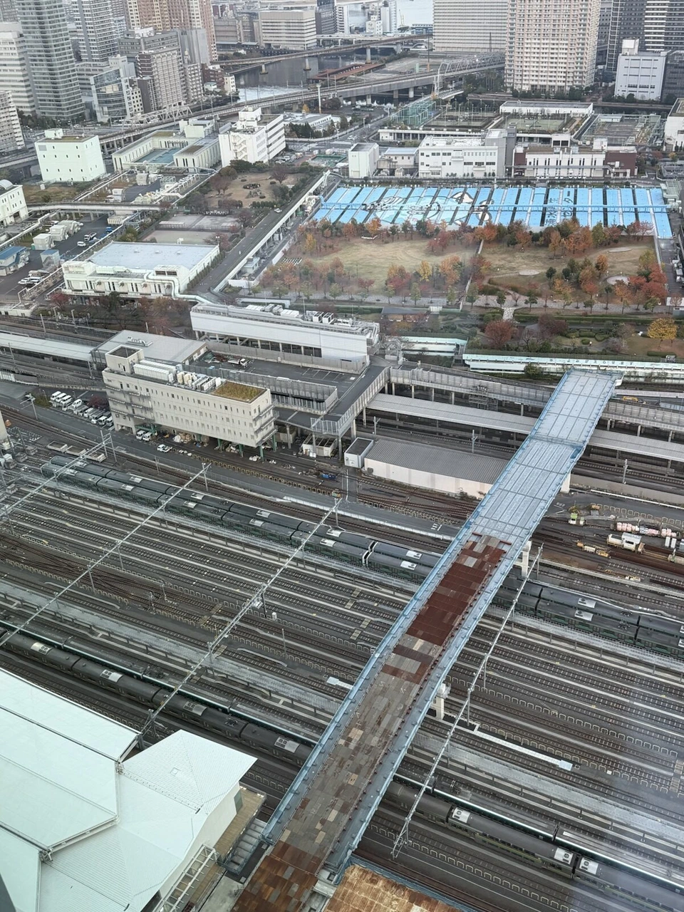 客室から真下に見下ろした線路と車両基地、紅葉した公園