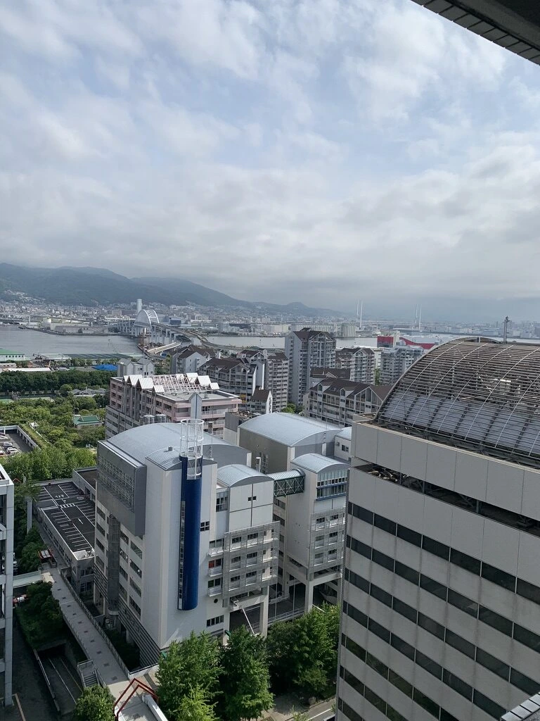 ドームのある建物と六甲アイランドの街並み、奥に海と山