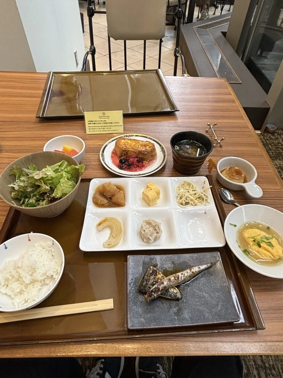 お盆にのせたごはん、サラダ、焼き魚、スープ