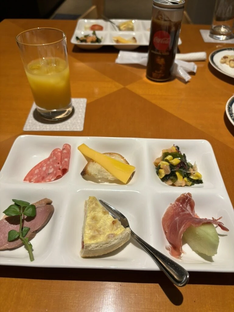 6つに仕切られた皿に生ハム、チーズ、キッシュ、ローストビーフを盛ったブッフェ