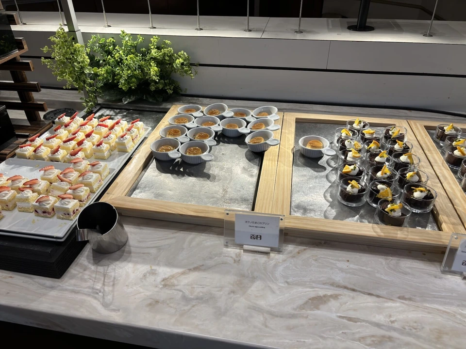朝食ブッフェ台に並んだショートケーキ、プリン、チョコレートのカップデザート