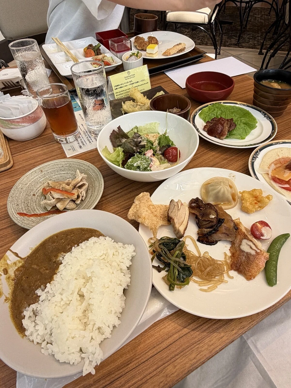 神戸ベイシェラトンのランチブッフェ。カレー、サラダ、肉料理の皿が並んだテーブル