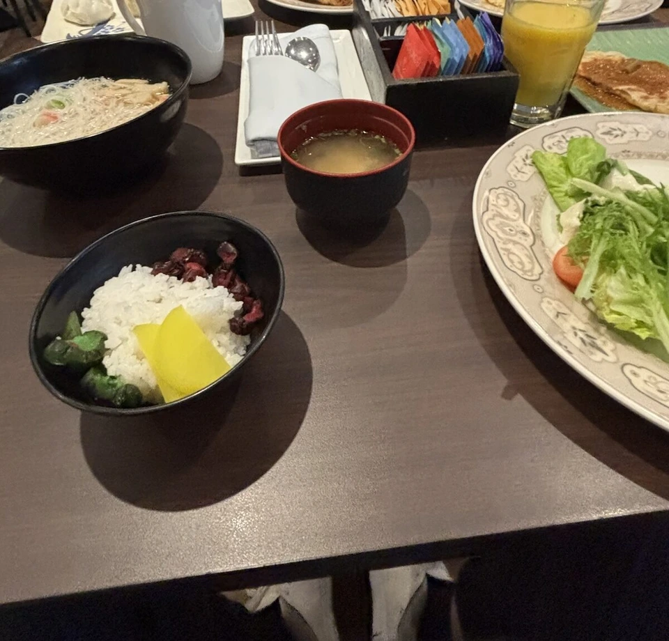 ル・メリディアン クアラルンプールの朝食のテーブル。麺のスープ、肉がのったご飯、味噌汁、サラダ、オレンジジュース、クロワッサン