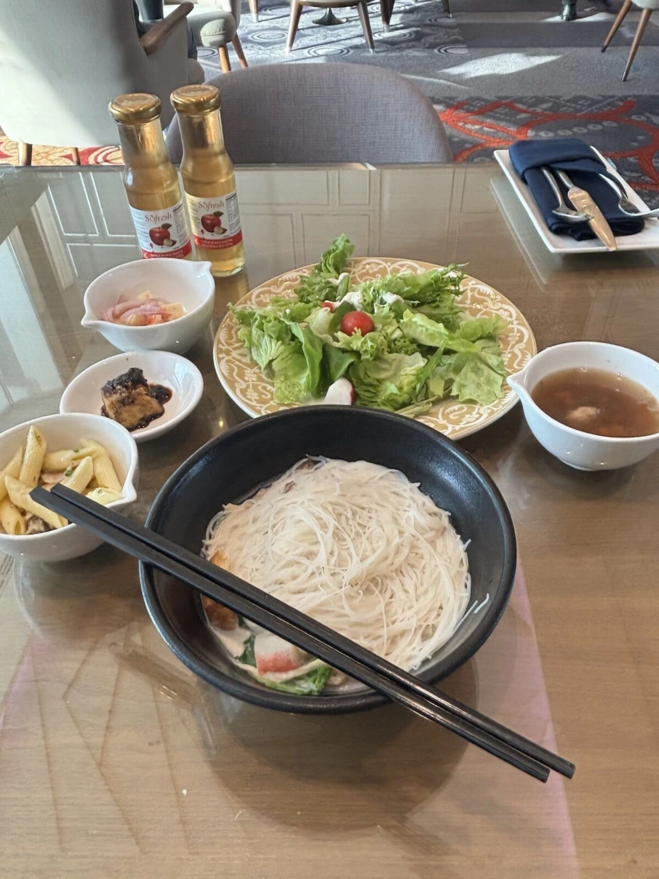 ル・メリディアン クアラルンプール33階のクラブラウンジの料理。スープに入った白い米麺、サラダ、小鉢が3つ、スープ、調味料の瓶2本