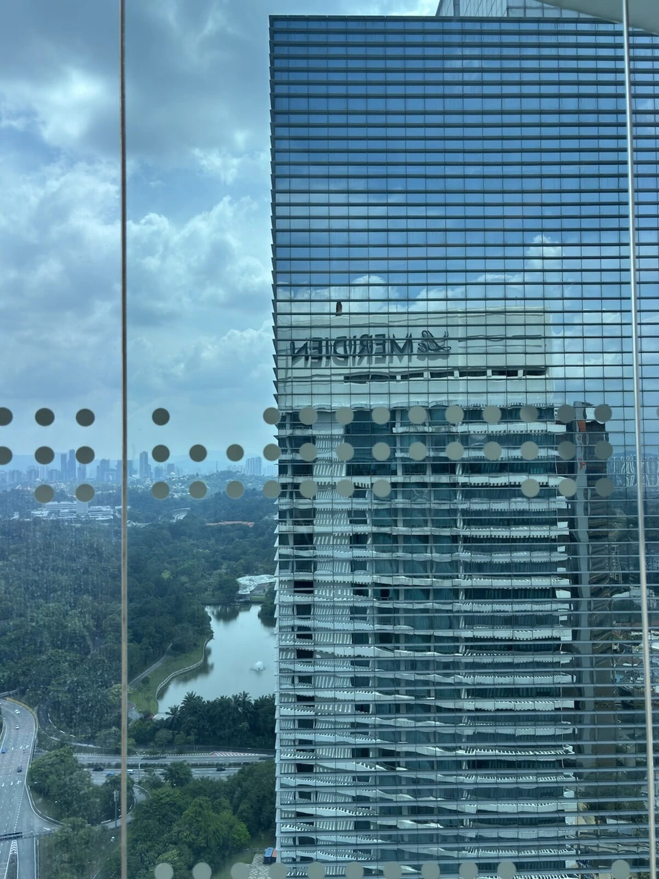ラウンジの窓から見た隣のガラス張りの高層ビル。ガラスにLe MERIDIENの文字が反転して映っている