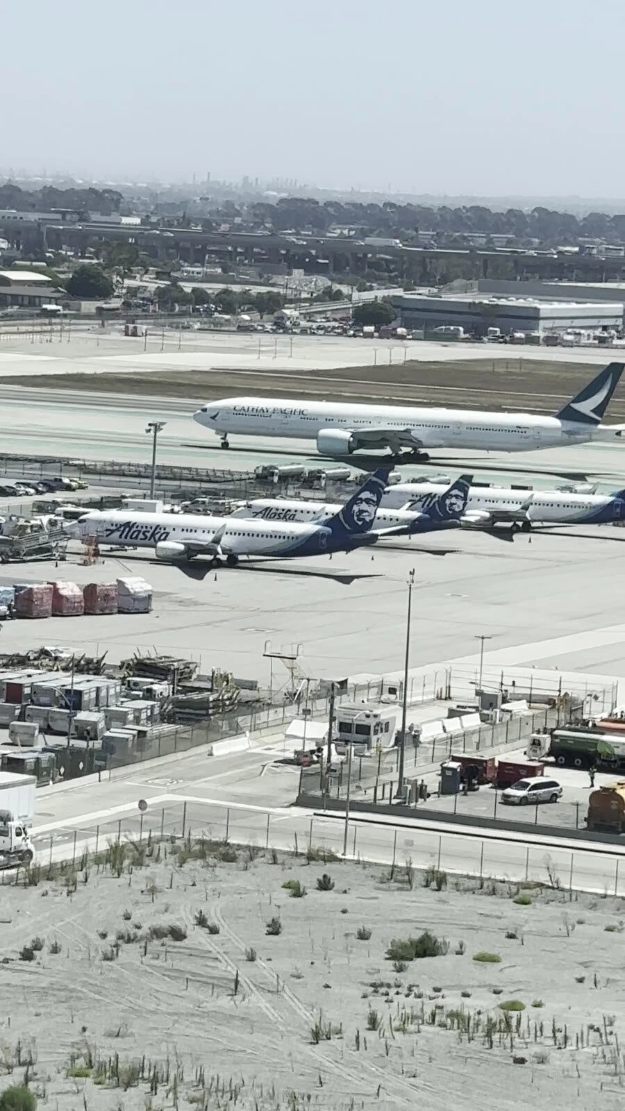 ロサンゼルス・エアポート・マリオットの客室の窓から見たLAX。奥を走るキャセイパシフィック航空の大型機と、手前に並ぶアラスカ航空の機体