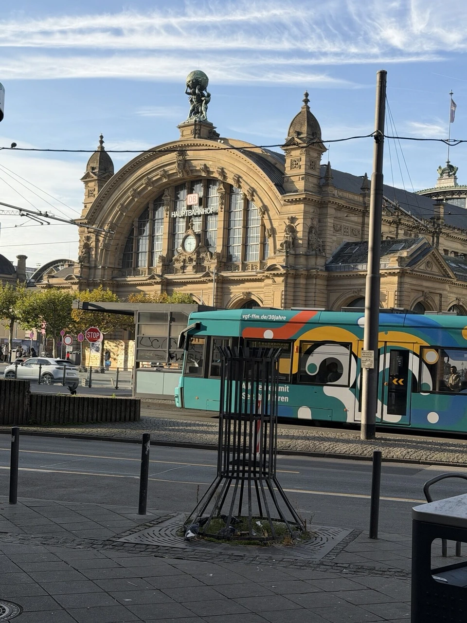 フランクフルト中央駅の駅舎と、駅前を走るカラフルな路面電車