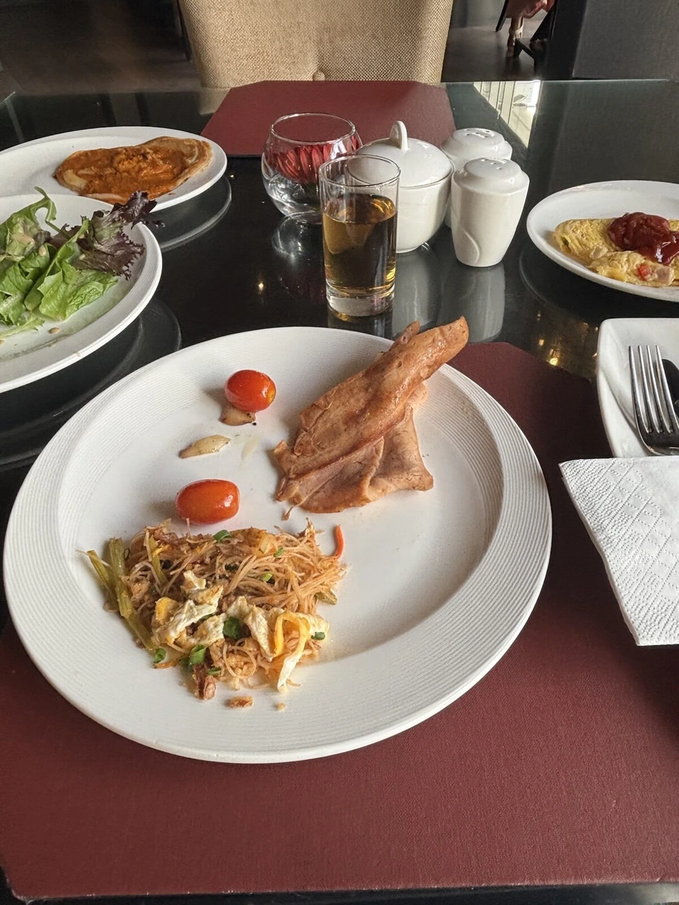 ザ・マジェスティック・ホテル・クアラルンプールの朝食。焼きビーフンとハム、ミニトマトの皿、サラダ、オムレツ、ジュース