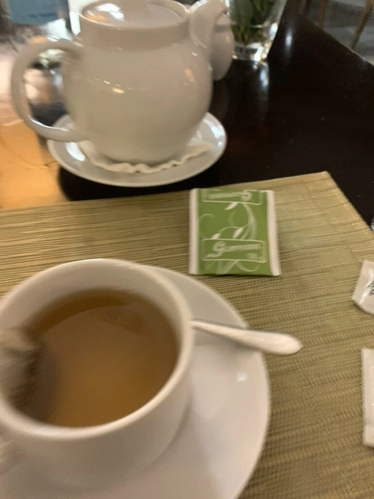 緑のランチョンマットの上のティーポットと紅茶