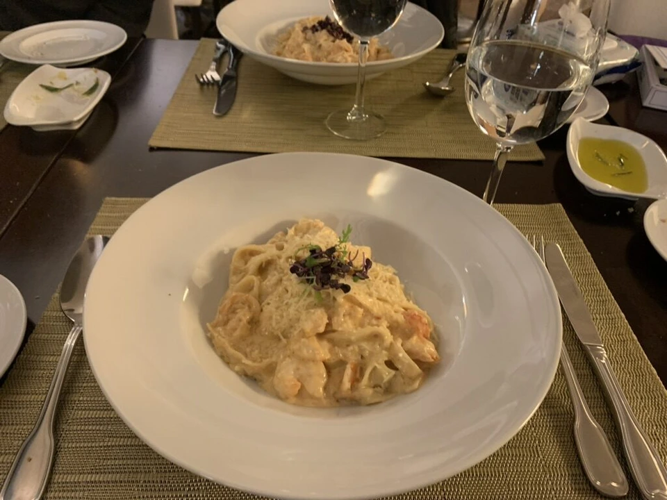 Escunaの、黒いトッピングを載せたクリームパスタ