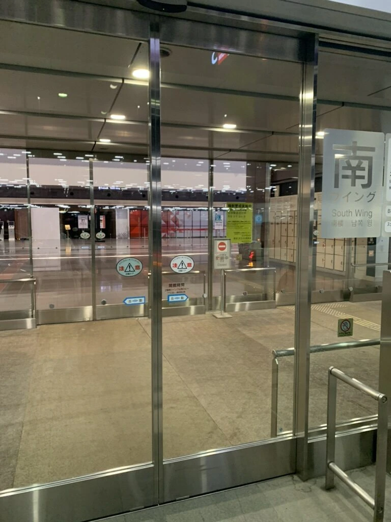 hotel MONday 羽田空港の始発シャトルの時間に着いた、まだ開いていない羽田第1ターミナルのガラス扉。奥に南ウイングの表示