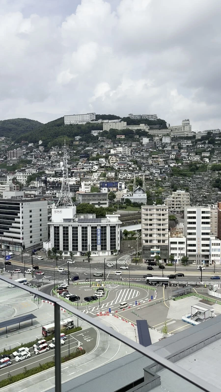 長崎マリオットホテルのバルコニーから見下ろした長崎駅前のロータリーと道路、山の斜面に建つ家々