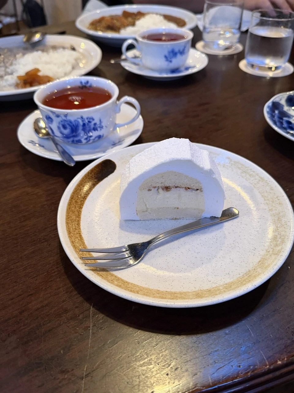 新富良野プリンスホテルの敷地にある珈琲 森の時計の、パウダーシュガーで覆われた白いケーキと青い花柄のカップの紅茶