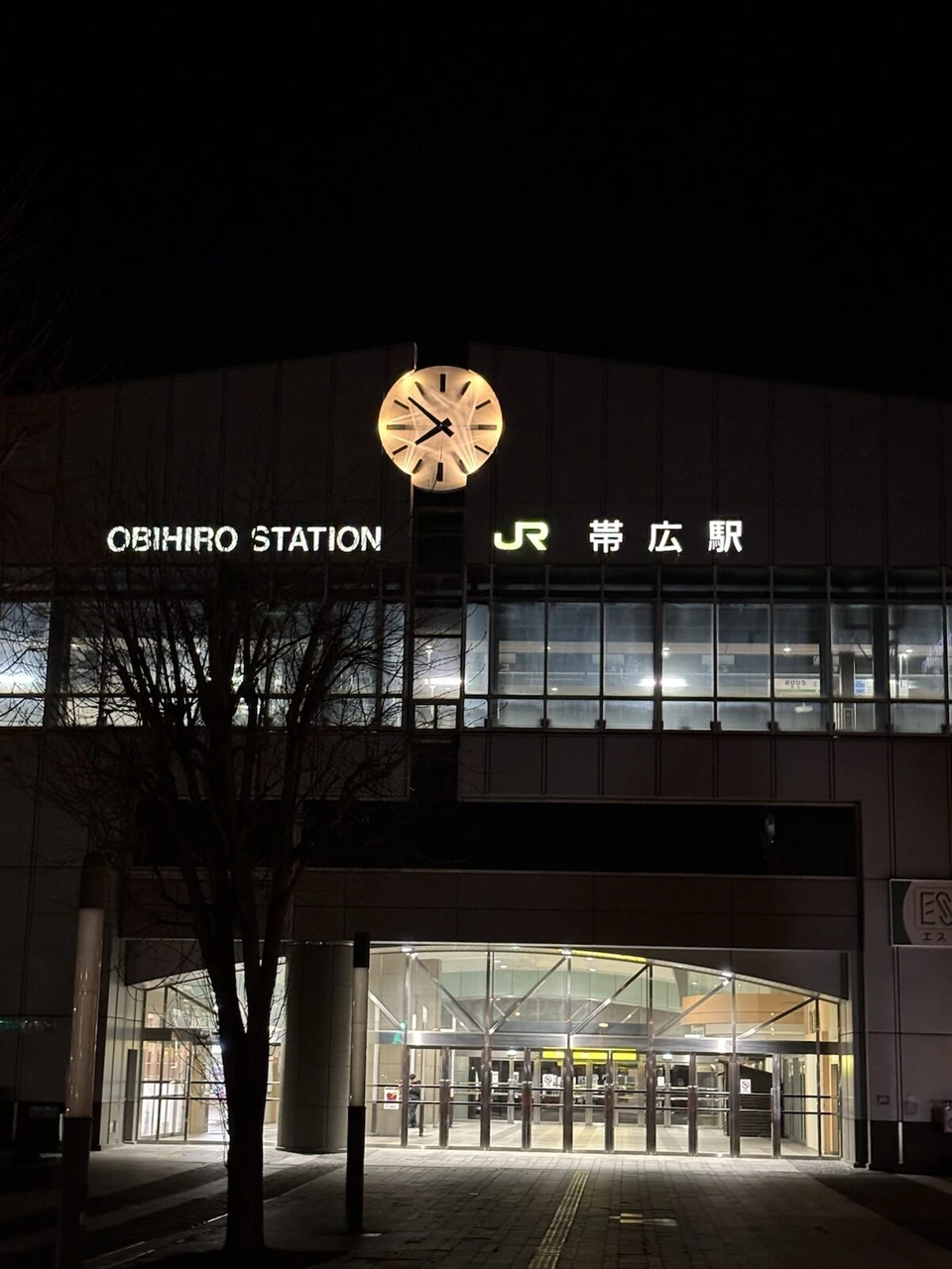 ホテル日航ノースランド帯広の目の前、夜の帯広駅。ライトアップされた時計と「OBIHIRO STATION」の文字