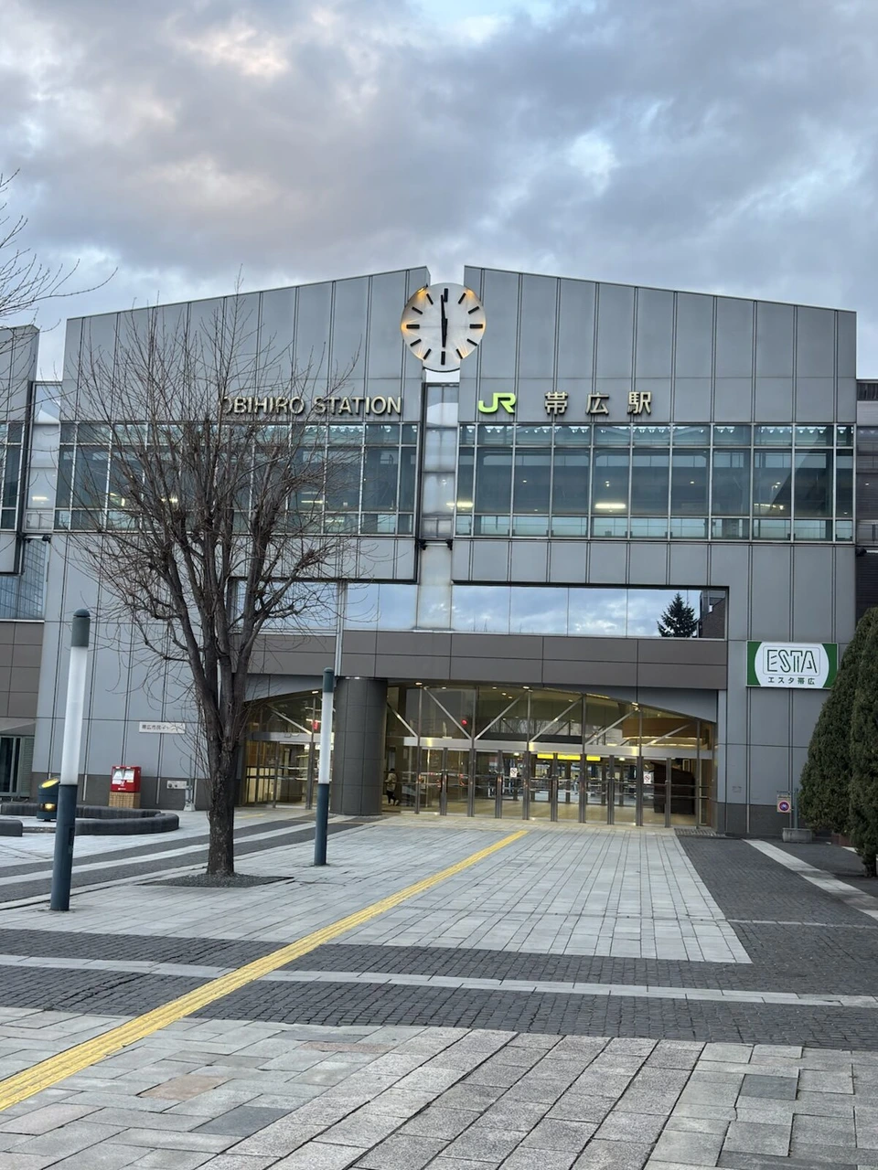 ホテル日航ノースランド帯広の前から見た夕方のJR帯広駅の駅舎。時計台と「JR帯広駅」の文字