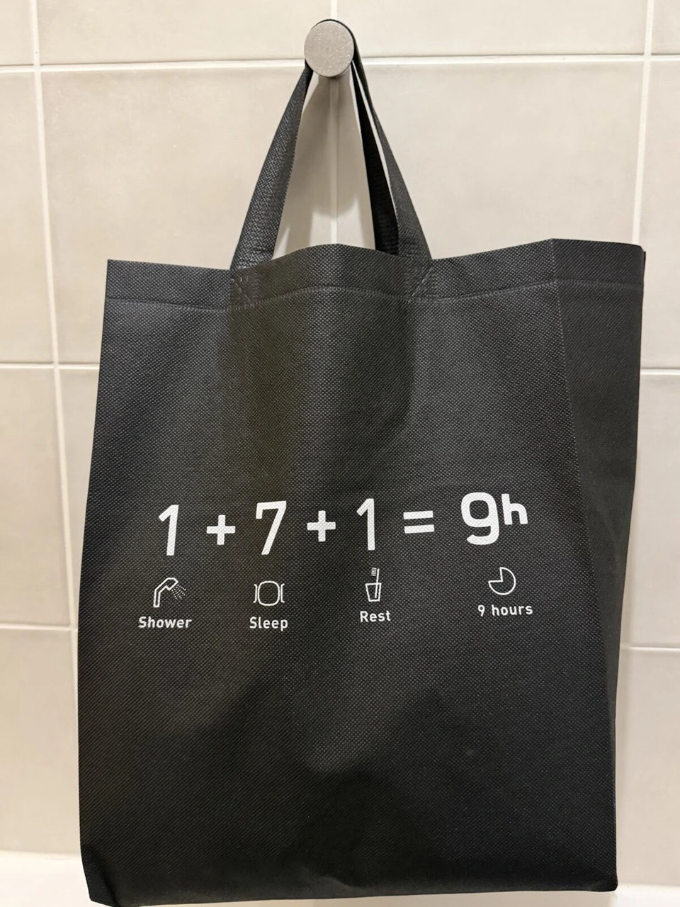ナインアワーズ浜松町の館内用の黒いバッグ。1+7+1=9hのロゴ