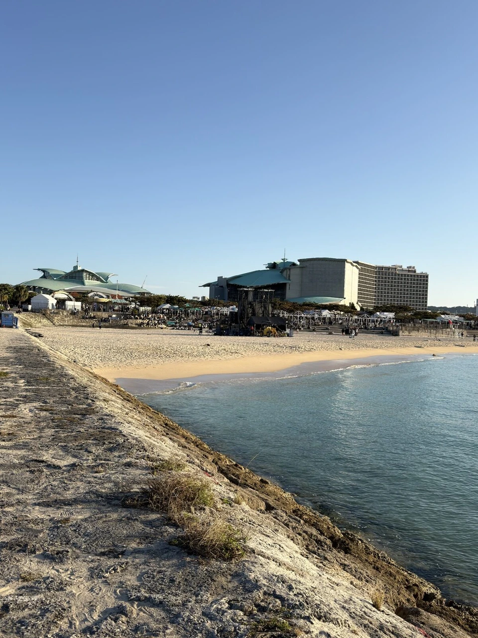防波堤から見たトロピカルビーチの浜辺。右奥に沖縄プリンスホテル オーシャンビューぎのわんの建物
