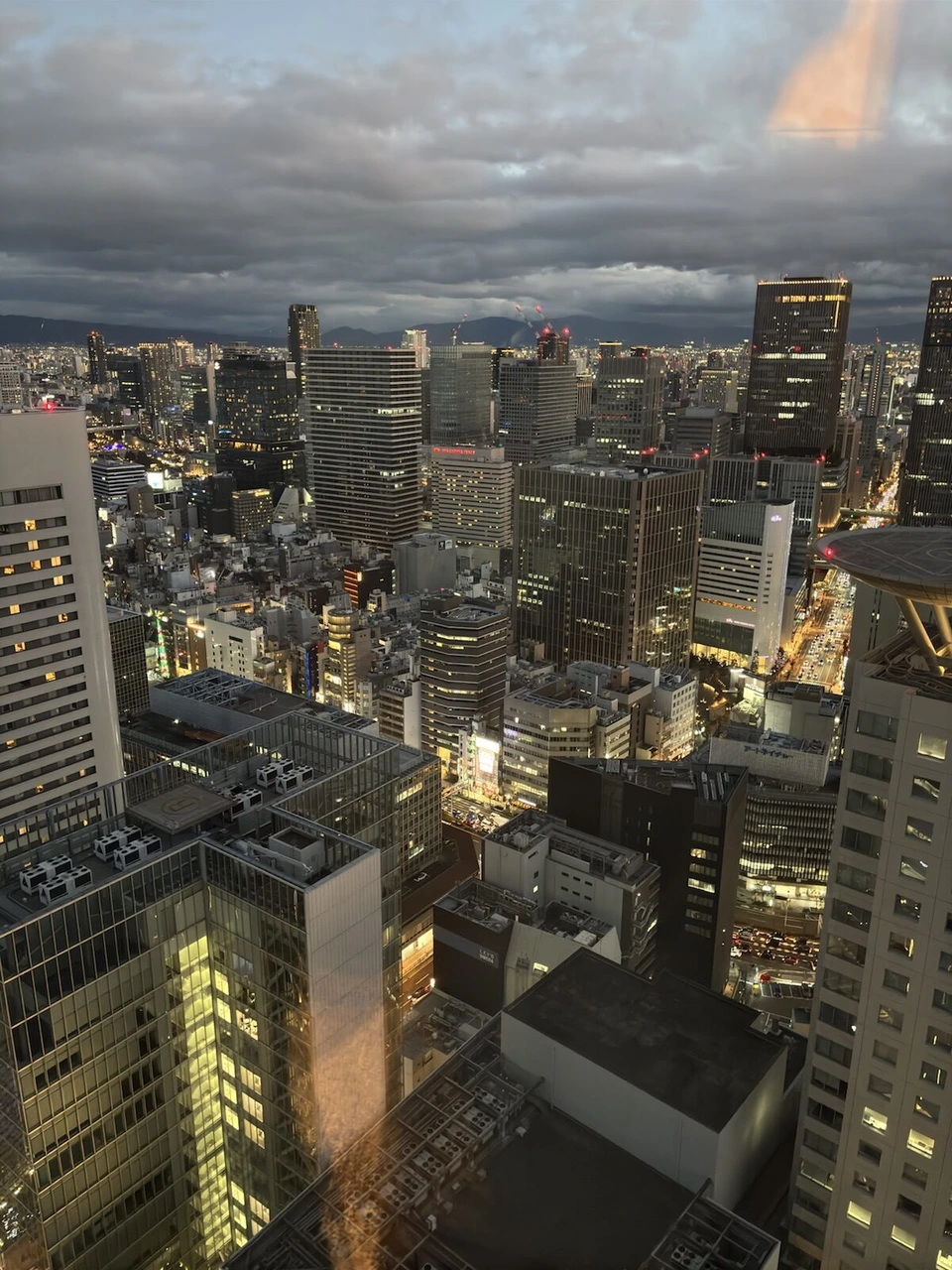 大阪ステーションホテルの窓から見た夕方の梅田。ビルの明かりがつき始めている