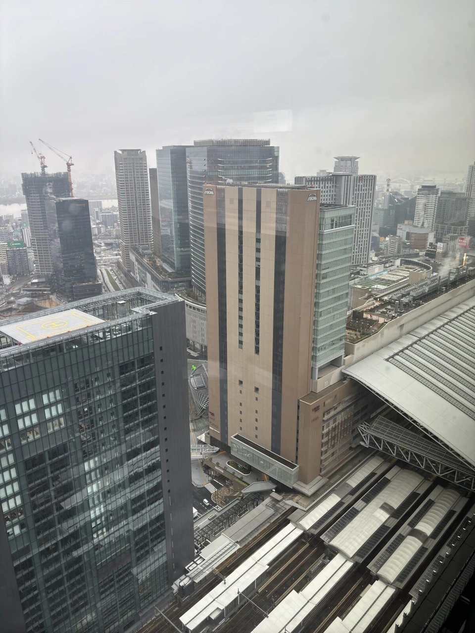大阪ステーションホテルのコーナーの窓から見下ろした大阪駅の線路と隣の高層ビル