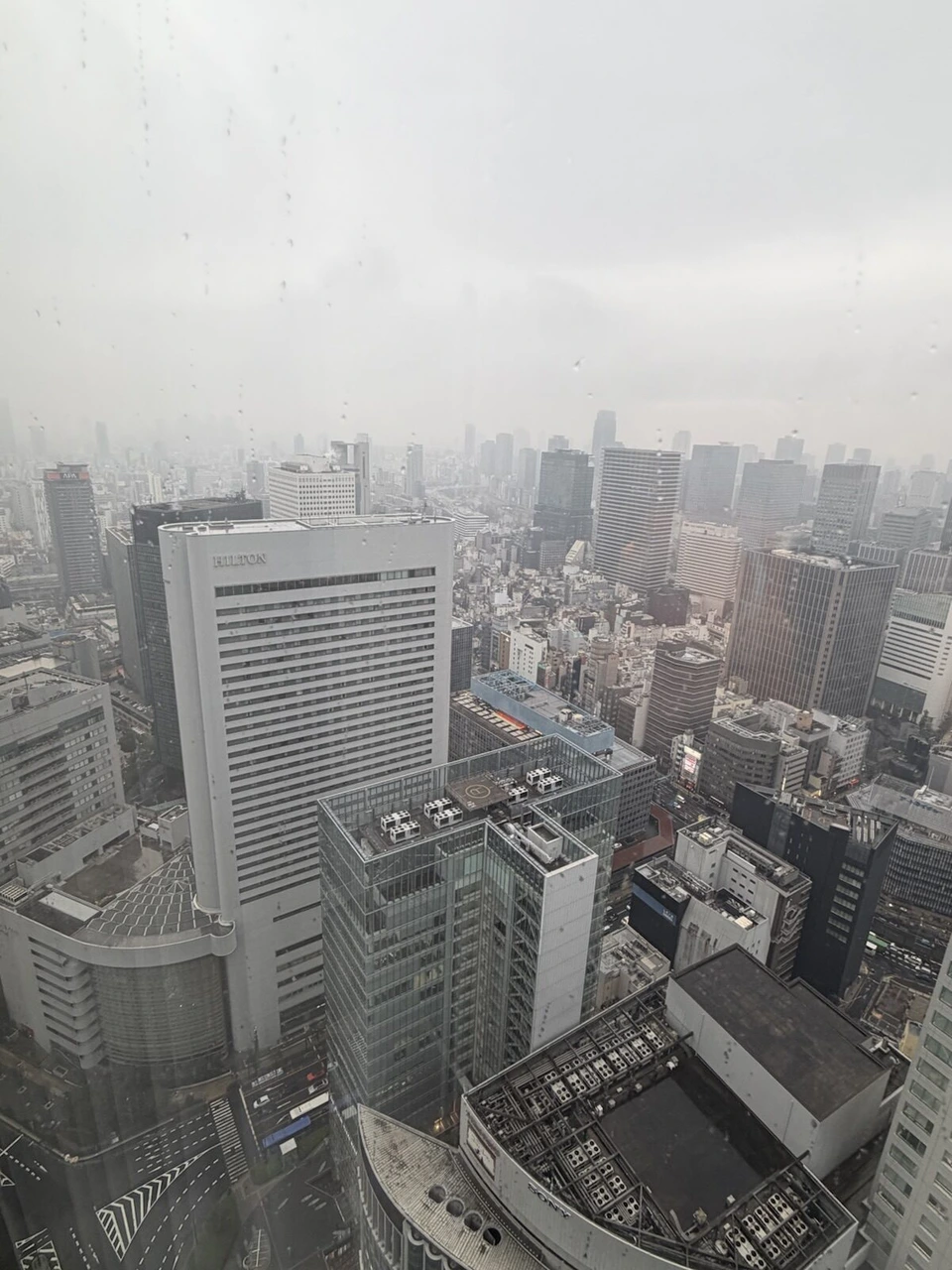 大阪ステーションホテルの雨で霞んだ窓からの梅田のビル群