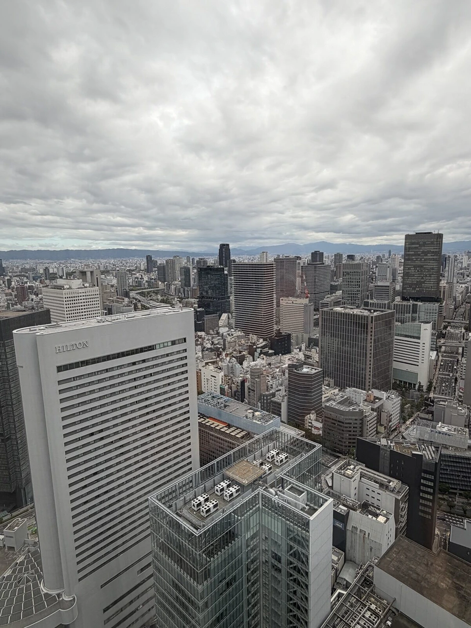 大阪ステーションホテルの曇りの午後に窓から見た梅田の白い高層ビルと街並み