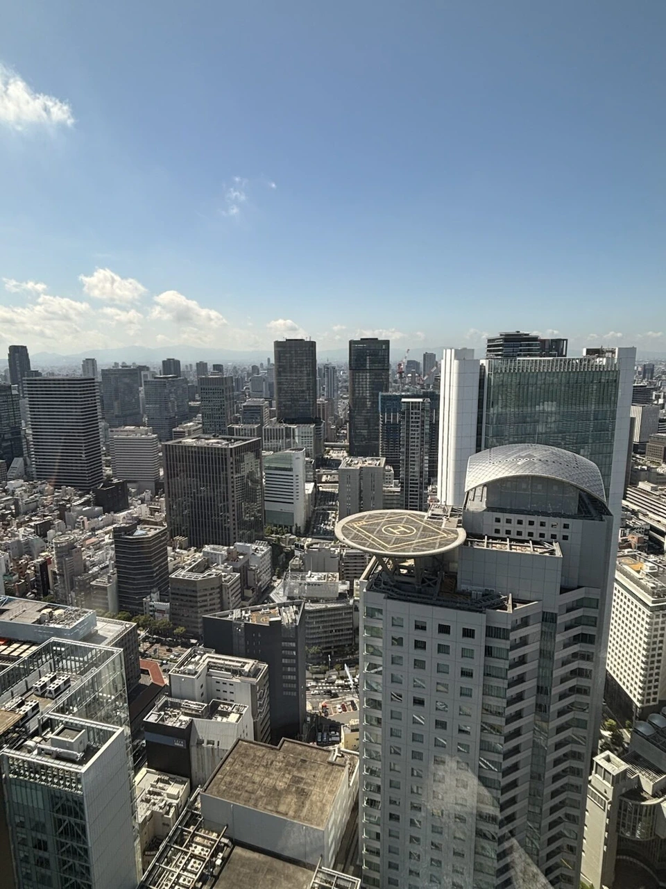 大阪ステーションホテルの晴れた朝の38階から見た梅田のビル群と青空