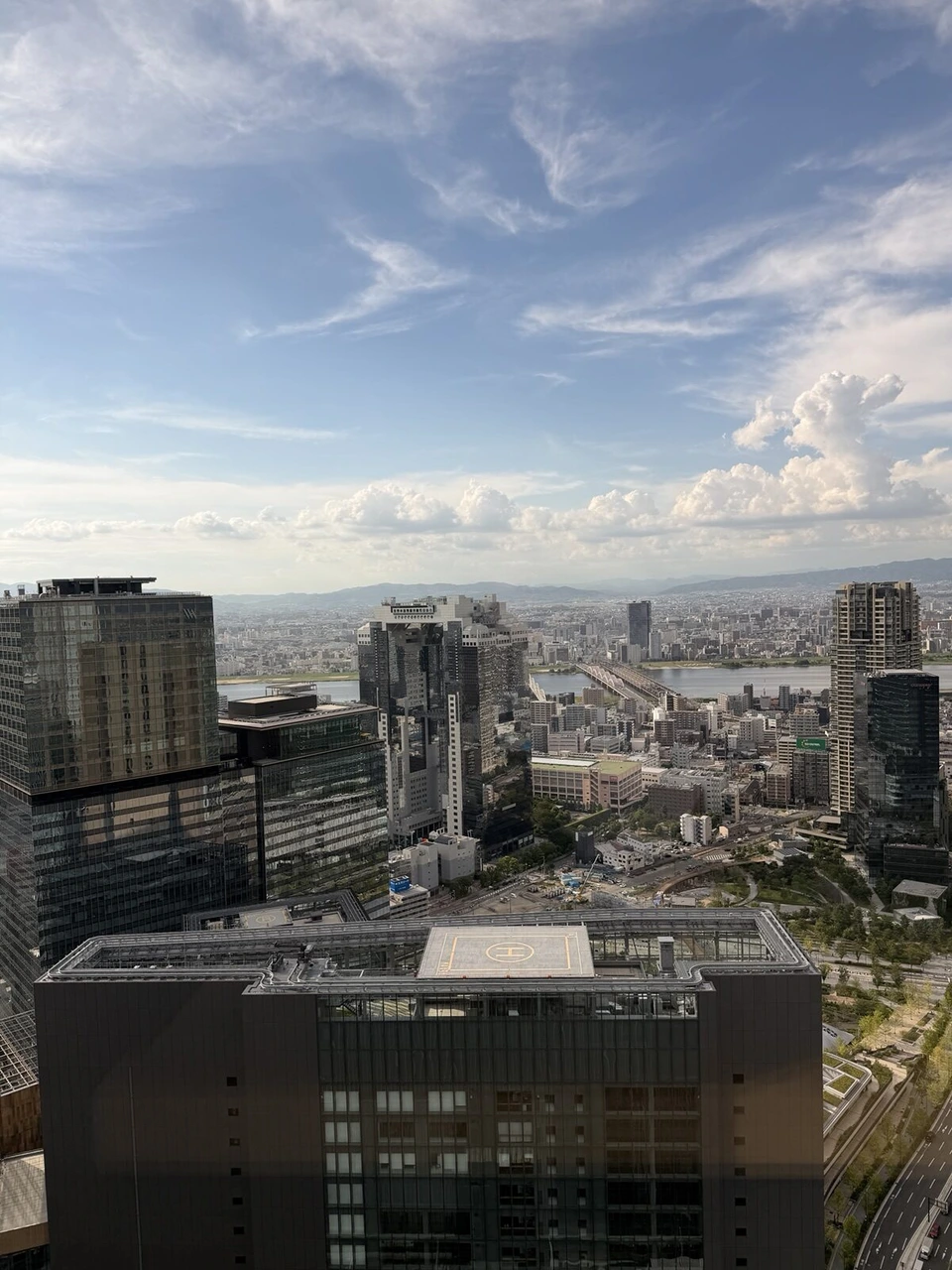 大阪ステーションホテルの38階から見た夏の夕方の梅田と遠くの海