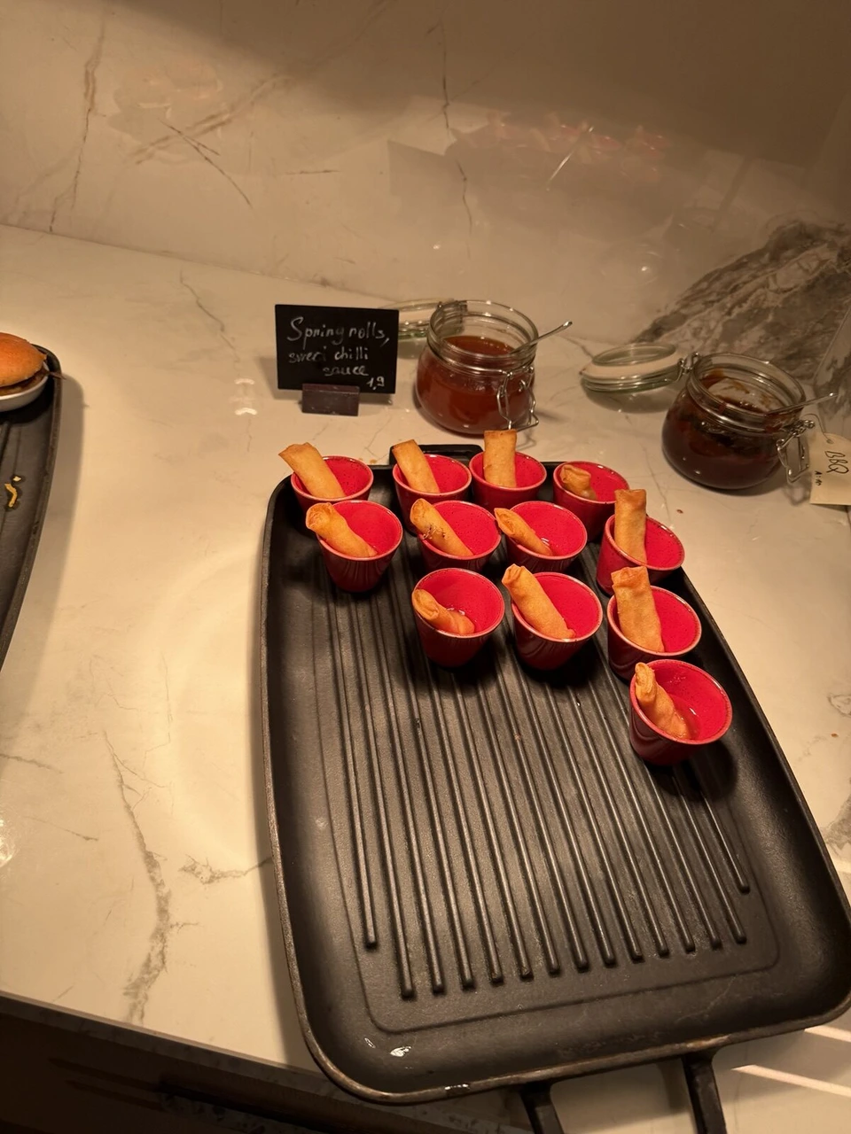 M Clubの夜の料理。赤い器に入った春巻きとスイートチリソース