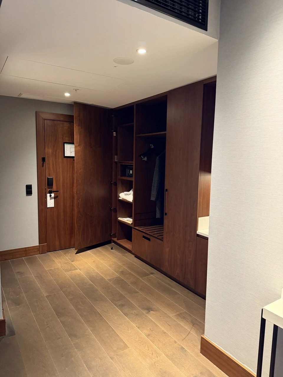 客室の入口と、木の棚とハンガーのクローゼット