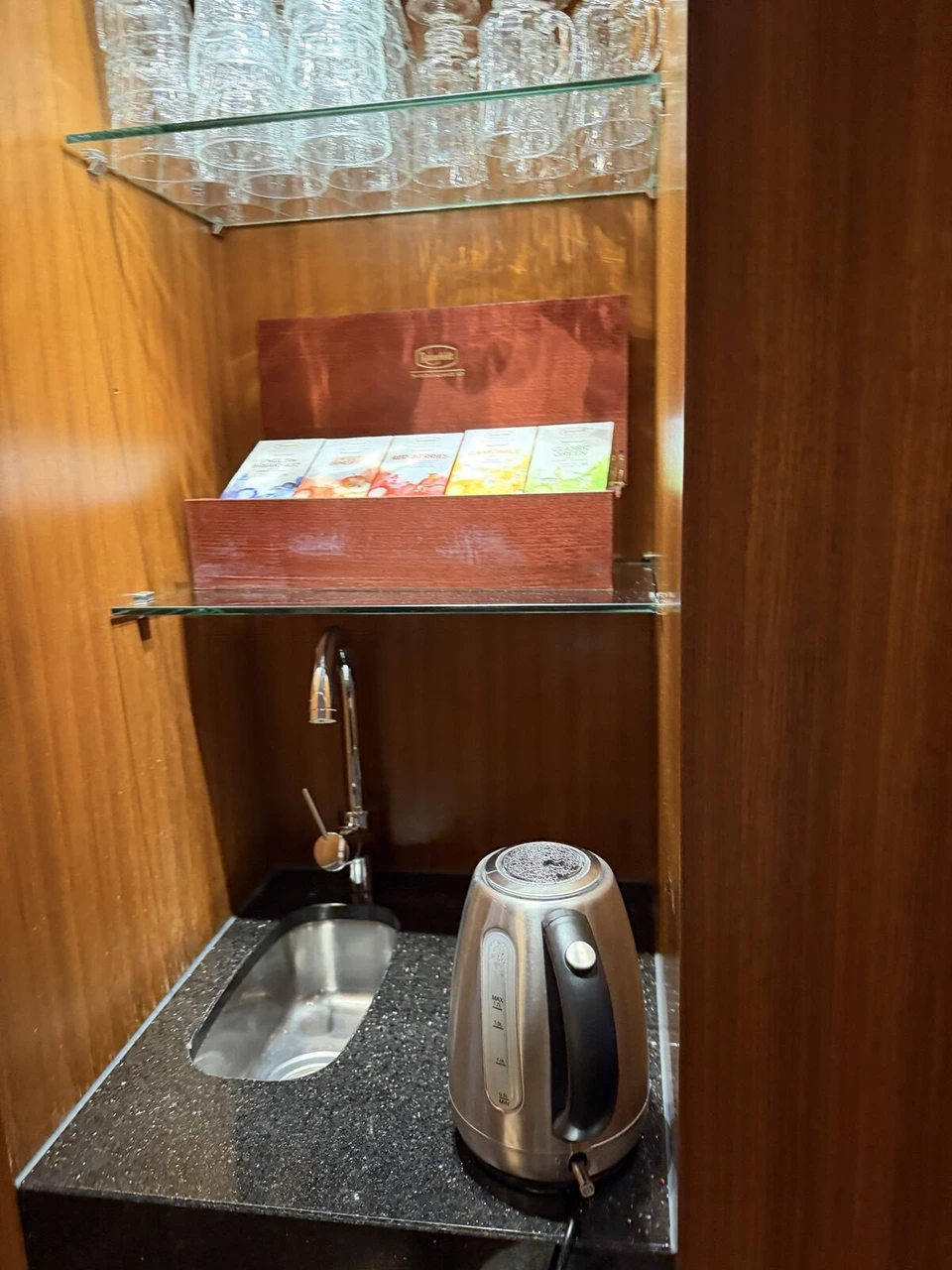 ラウンジの小さなシンクと電気ケトル、ティーバッグの箱とグラス