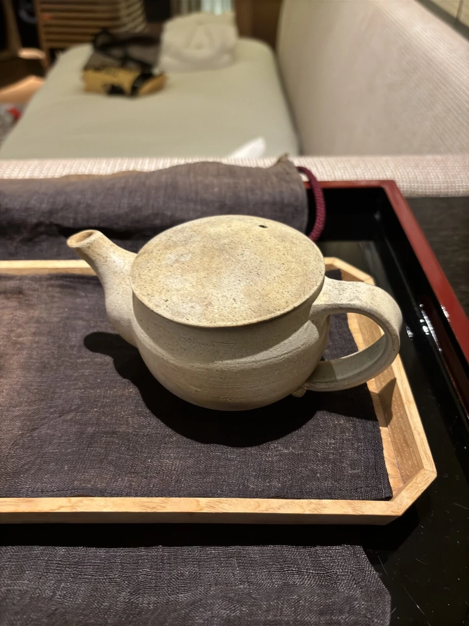 漆の盆にのった白い陶器の急須