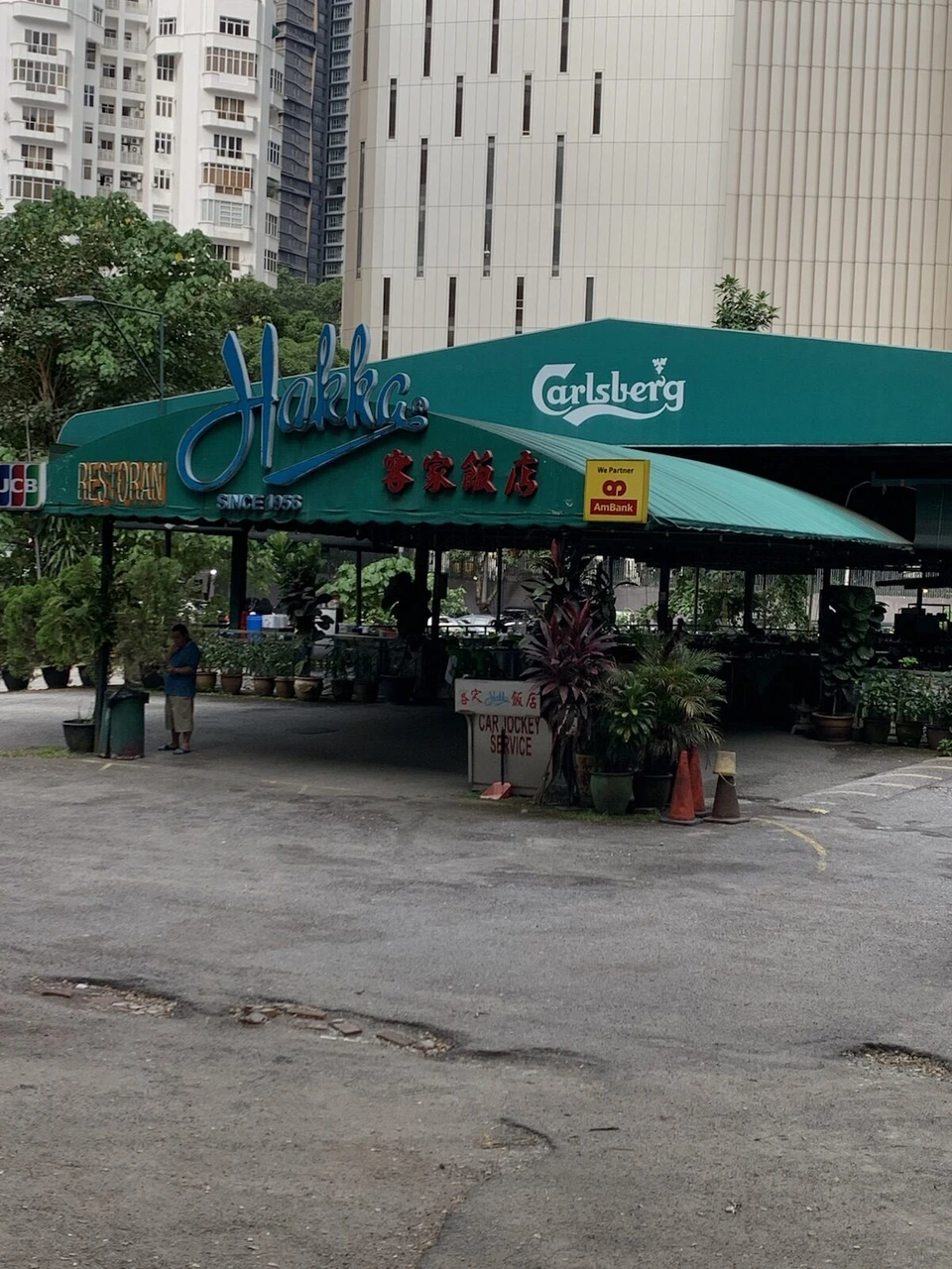緑のテントに青いHakkaのネオンと客家飯店の文字が付いたレストランの入口