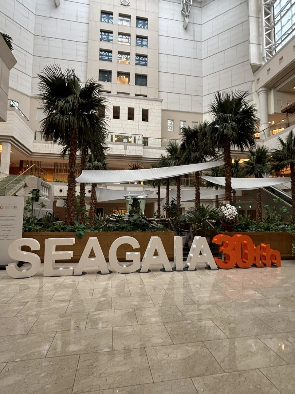 ヤシの木が並ぶ吹き抜けのロビーに置かれたSEAGAIA 30thの文字のオブジェ