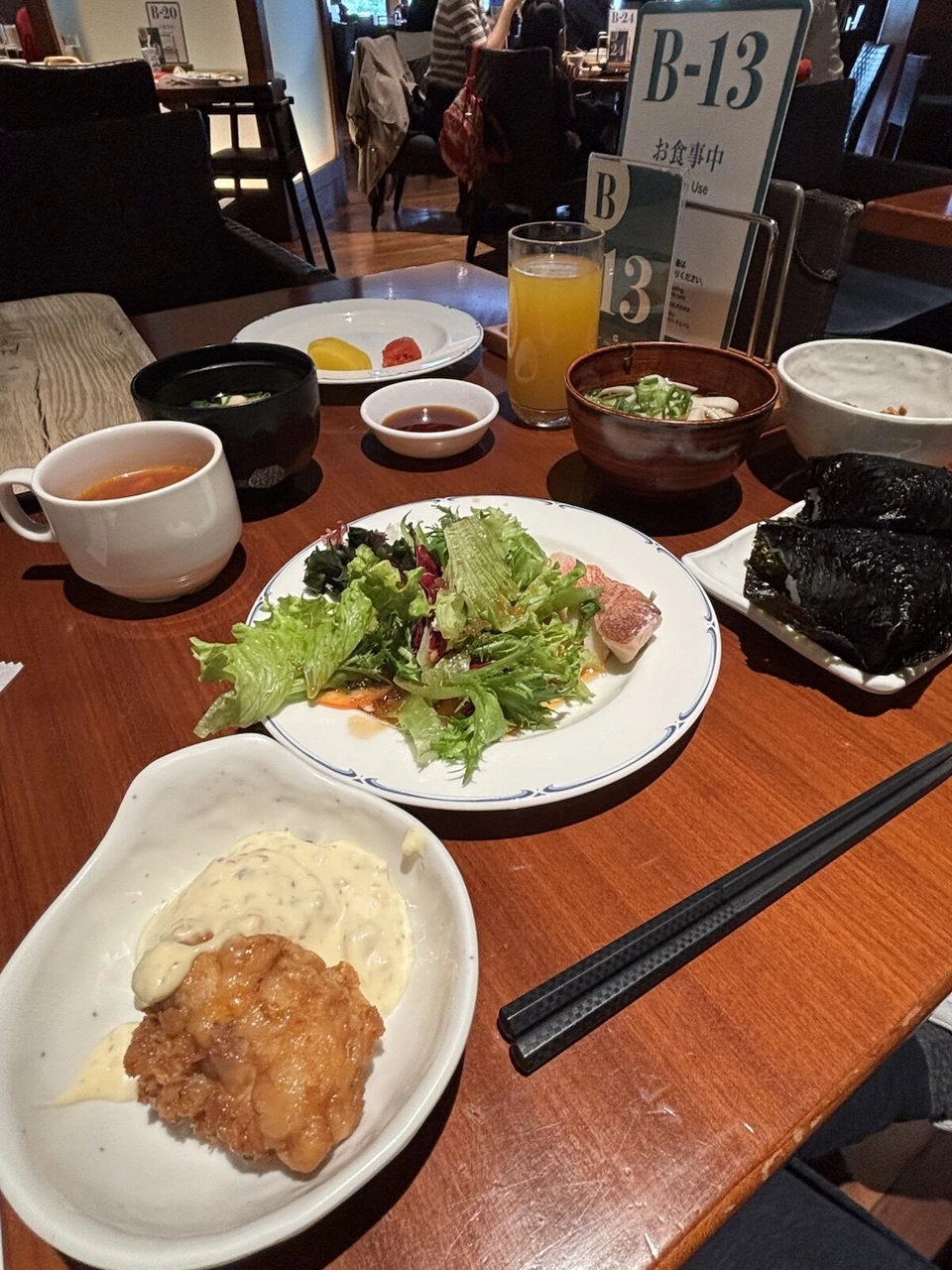 ビュッフェの朝食。サラダ、ローストビーフ、唐揚げのタルタル、おにぎり、味噌汁、オレンジジュース